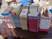 Overview of five bags filled with softcover books showing all bags and the book spines and covers mostly visible.