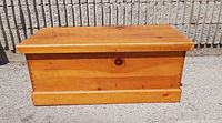 Blanket box closed, showing rectangular shape, wood grain, and dovetail joints.