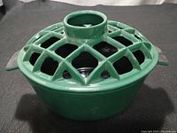 Cast iron steamer with green enamel lattice lid, side view showing detail of latticework