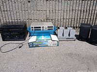 Overview of all electronics including stereo amplifier, combo cassette deck and record player, boxed JVC DVD player, and speakers.