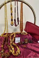 Overview of hanging necklaces, chip necklaces on draped fabric and cosmetic bag