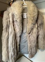 Front view of the blue fox fur jacket on hanger, showing the fur texture and collar.