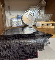 Photo showing vintage French spice boxes stacked, clear glass bowl, guitar-shaped cake pan, black placemats laid flat, baking rack and timer in background