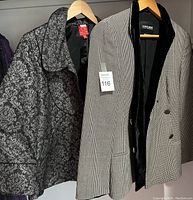 Photo of two ladies designer jackets on hangers, Giorgio Armani and Oscar De La Renta, showing patterns, size tags and labels.