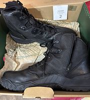 Photo showing the pair of black Danner men's boots inside box with tissue paper.