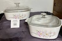 Photo showing both vintage CorningWare square ceramic baking dishes with glass lids, floral pattern in pale grey and pink