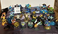 Photo showing 20 Skylanders figures arranged on a surface, featuring a variety of characters including fire, water, and earth elemental themes.