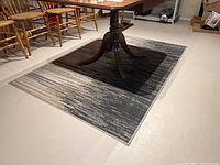Area rug under dining table showing gradient pattern and condition