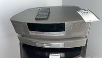 Front view of Wave Music System III main unit stacked on 3-disc changer with remote on top