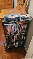 Three shelves stacked with DVDs and Blu-rays including action titles such as Star Wars trilogy, Avatar, and James Bond, among others.