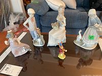 Overview of all five porcelain figurines on a table.