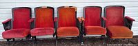 Front view of 5 vintage theater seats in 3 and 2 piece sets, red and orange velvet upholstery, cast iron bases