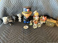 Full view of lot including figures, coin bank, and tin box