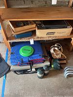 Overview of the camping gear lot showing sleeping pads, frisbee, backpack, hammock strap and Coleman box.