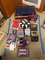Overview photo showing many game boxes, books, cards, dice, poker chips, and backgammon set in one image