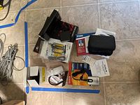 Overview photo of all items including pocket router, NexStar3 dock, SanDisk ImageMate, D-Link adapter, cables, and manuals on floor with tape markings.