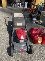 Front view of mower showing deck, engine cover, and grass bag