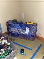 Lego Mindstorms Robotics Invention System 1.5 original box next to a bin of assorted robotic parts and a small assembled piece, showing overall contents of the lot.