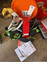 Photo showing the full roofing safety kit arranged on the floor including harness, tether, anchor, and manuals.