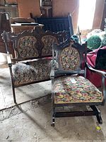 Both vintage upholstered settee bench and matching chair seen together; floral fabric upholstery visible along with carved wood frames; wear and damage seen.