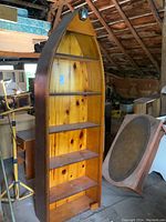 Front view of boat-shaped pine bookshelf showing five shelves and curved exterior