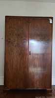 Front view of vintage cedar lined wood cabinet showing two doors with metal pull handle and decorative wood grain finish.