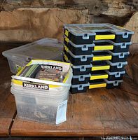 Overall view of six Stanley stacking organizers and two plastic bins of assorted hardware on rustic wood surface.