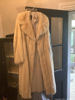 Full front view of blonde mink coat hanging on door