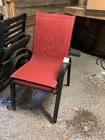 Single red fabric patio chair with black metal frame, showing seat and backrest, front angle.