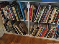 Books arranged on a white bookshelf showing a variety of colors, sizes, and titles focused on horses, history, and other subjects.