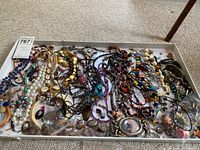 Overview of assorted costume jewelry arranged in a tray
