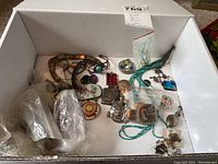 Overview of assorted costume jewelry items in white box