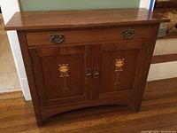 Front view of oak Stickley sideboard showing decorative inlay and hardware