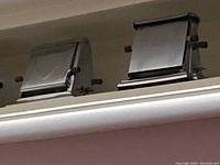 Close-up photo of two vintage metal toasters side by side showing classic design and side handle.