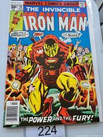 Front cover of Iron Man #96 comic featuring Iron Man in red and yellow armor with explosive effects and crowd in background.