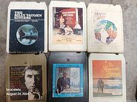 Top view of six 8-track cartridges showing individual album covers and labels including The Billy Vaughn Singers and Mancini Story.