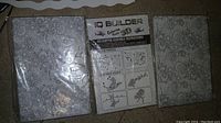 Two large sealed bricks of white modeling clay with embossed ornate patterns and a 3D helicopter assembly instruction sheet between them