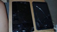 Top view of two tablets showing cracked screens, one is larger with a shattered display, other is smaller with cracks on the screen.