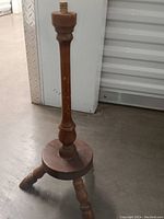 Full view of the wooden pedestal base showing a round platform and turned central column with attached legs.