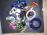 Photo showing assorted bracelets with colorful beads in various shapes and materials.