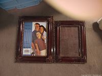 Two rectangular brown wood-tone picture frames side by side, one with photo insert showing three people.