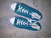 Top view of the green Converse sneakers showing the upper canvas, white toe caps, and laces