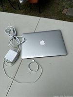 Closed MacBook Pro A1502 next to MagSafe power adapter on table
