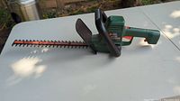 Full view of Black & Decker Autostop hedge trimmer showing green and black housing and 16 inch blade.