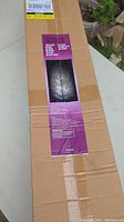 Box with label showing product details and image of the LED Christmas tree lit with white lights.