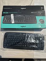 Photo of Logitech MK320 wireless keyboard in sealed plastic wrap on box with branding and product image