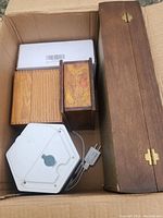 Top view of box contents showing wooden boxes, the small electric fan, and the sealed TED Pro Home box inside the cardboard container.