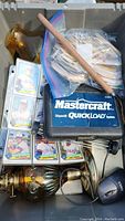 Photo showing sheets of baseball cards in plastic sleeves, Mastercraft QuickLoad tool box, amber glass lantern, wooden stick, and some cables.