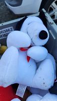 White Snoopy plush toy in bin showing some stains and overall condition