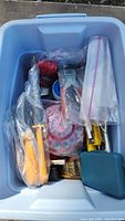 View into blue plastic tote showing various tools including clamps with yellow handles, rivet punch, sockets, and bags with rivets and drill bits